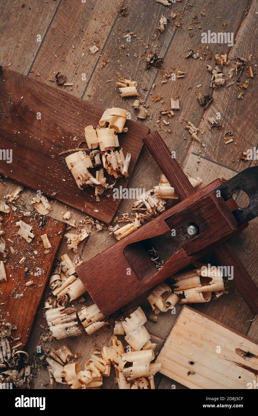 Une raboteuse à main et des copeaux de bois sur le sol carrelé Banque D'Images