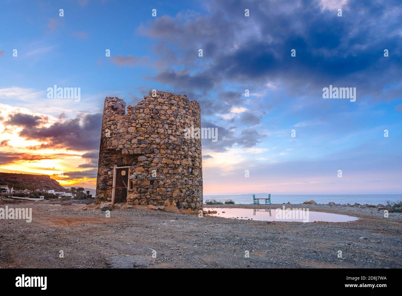 Un ancien moulin à vent près du village de pêche traditionnel pictural de Milatos, Crète, Grèce. Banque D'Images