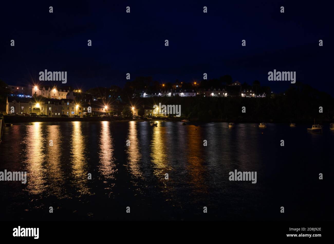 Paysage urbain, de Portree la nuit avec les lumières du lampadaire reflétées sur l'eau de mer, île de Skye, Royaume-Uni Banque D'Images