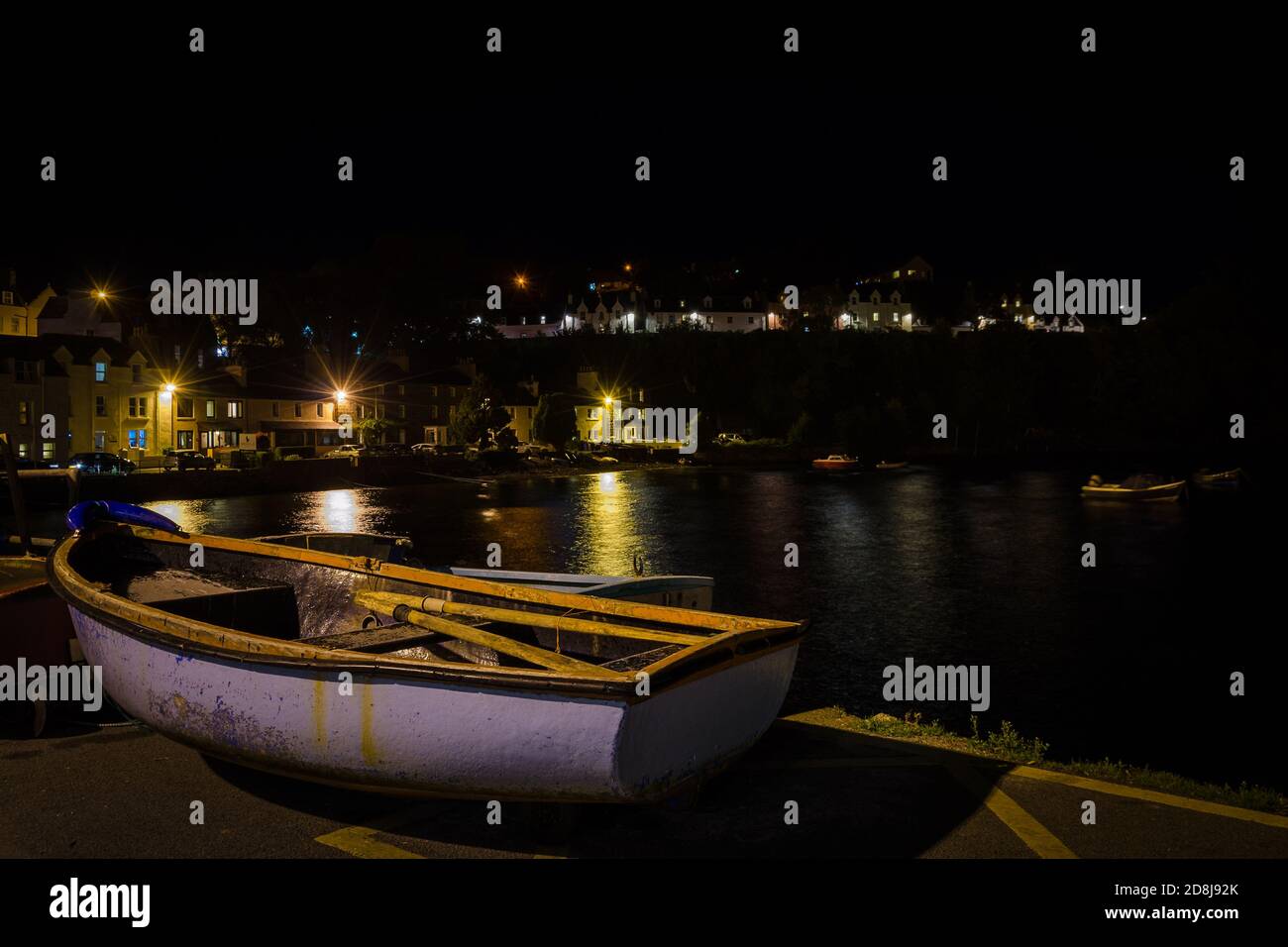 Paysage urbain, de Portree la nuit avec les lumières du lampadaire reflétées sur l'eau de mer, île de Skye, Royaume-Uni Banque D'Images