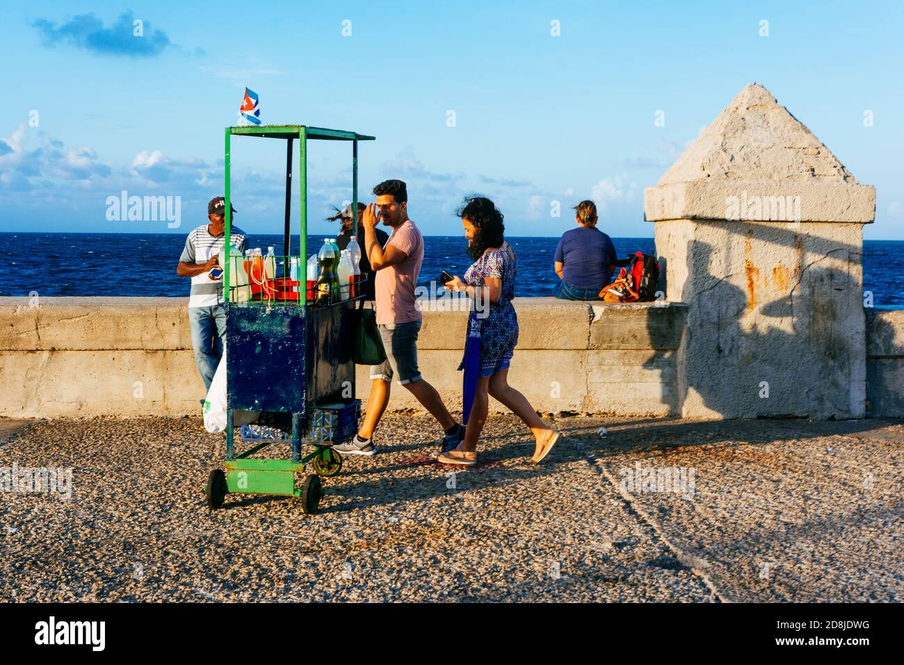 Les gens marchent au coucher du soleil sur le malecon. Le Malecón, officiellement Avenida de Maceo, est une vaste esplanade, route et digue qui s'étend sur 8 km Banque D'Images