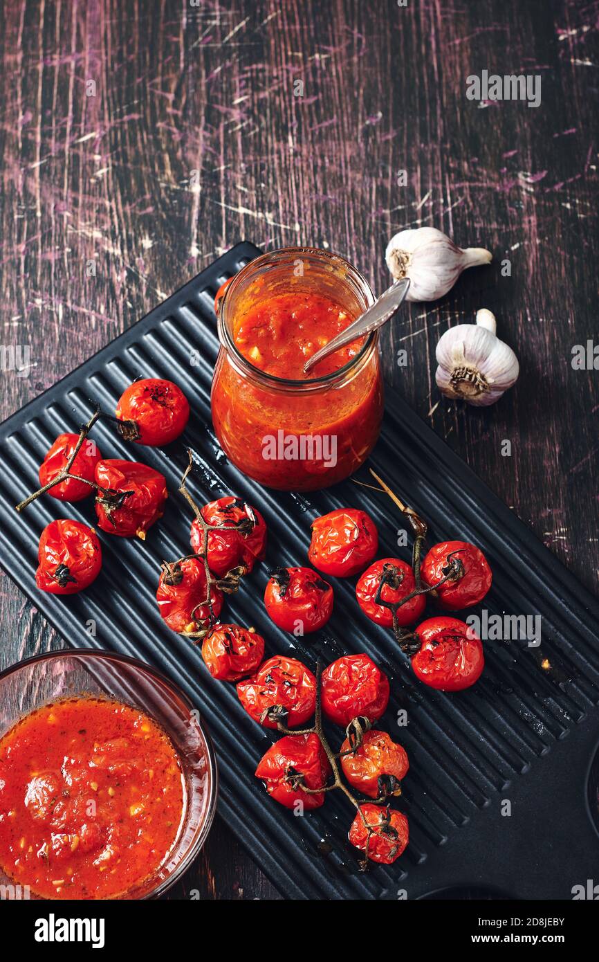 Sauce tomate et ingrédients sur fond de bois sombre. Banque D'Images