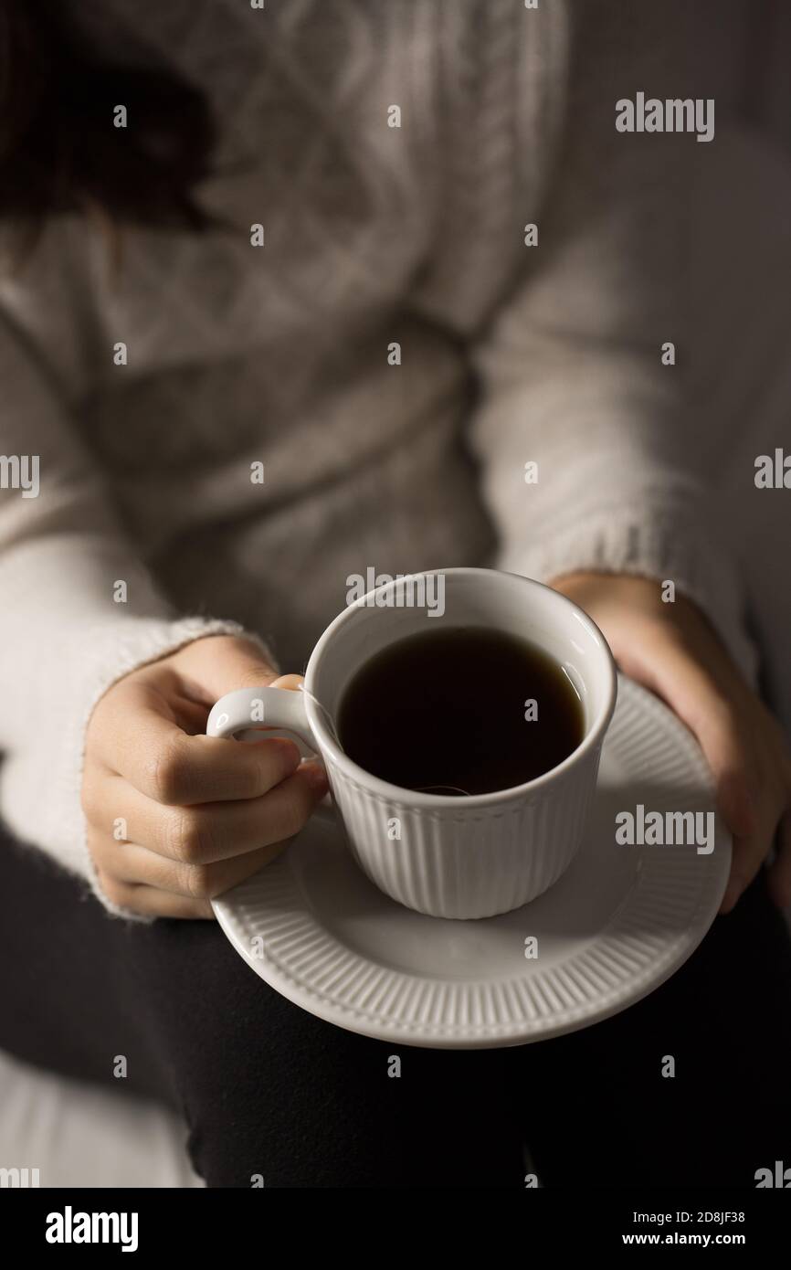 Fille avec tasse de thé, mains détails Banque D'Images