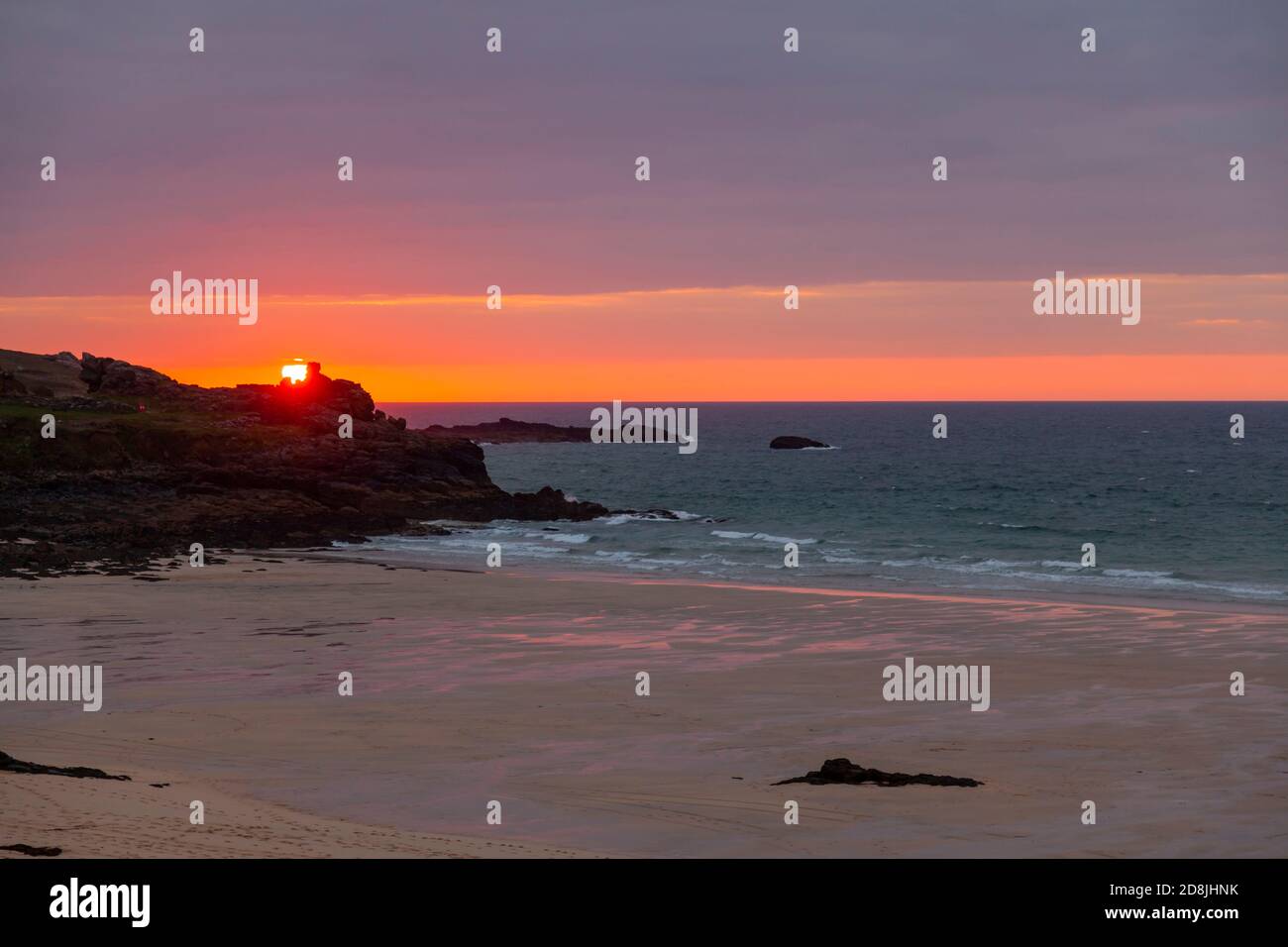 Image d'un coucher de soleil sur l'océan Atlantique tel que photographié de la côte sauvage de Cornwall près de St. Ives. La photo montre une baie, plage de sable, mer calme, c Banque D'Images