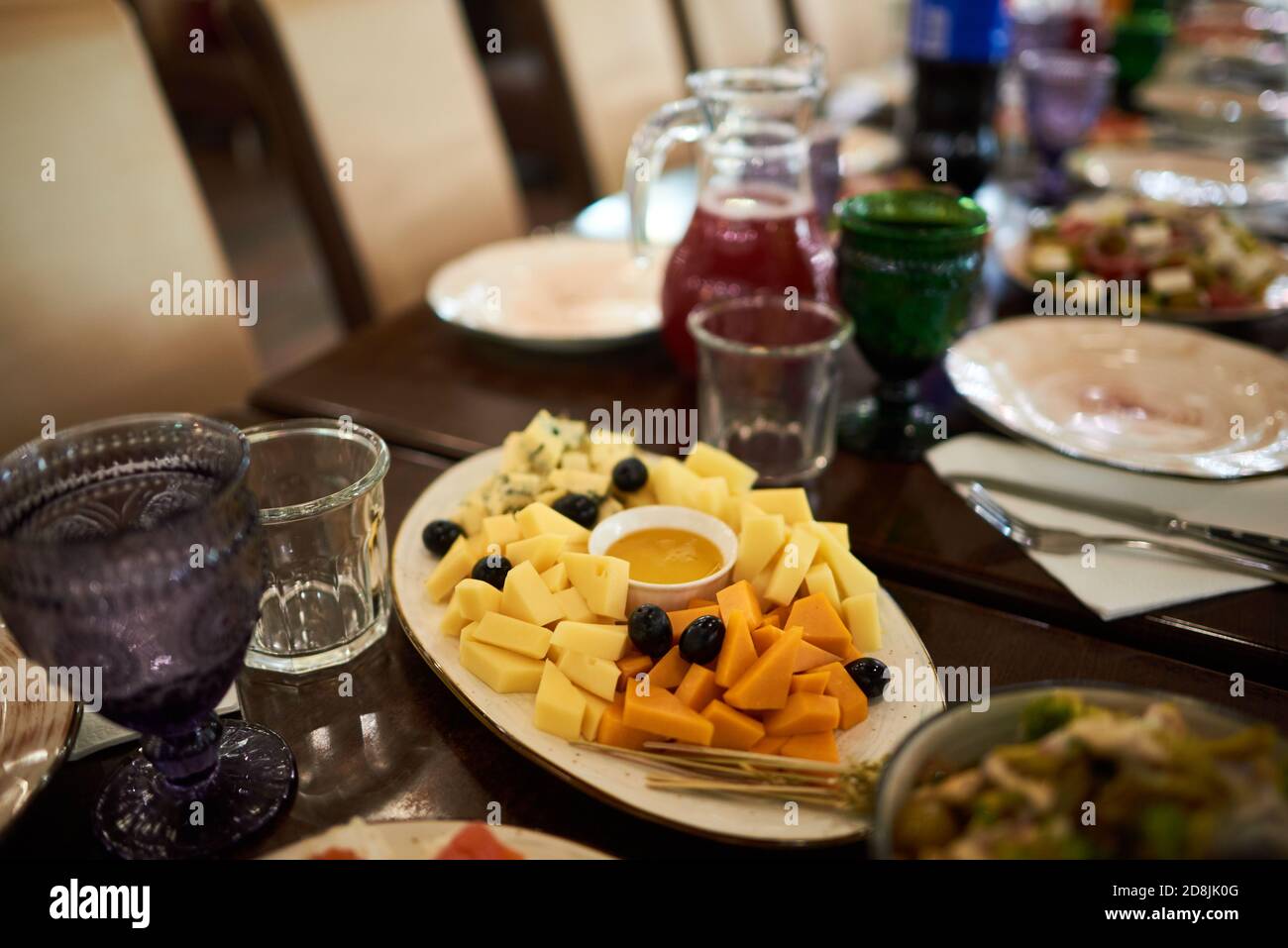 Assiette de fromages avec différents types de fromage avec miel, raisins et pailles Banque D'Images