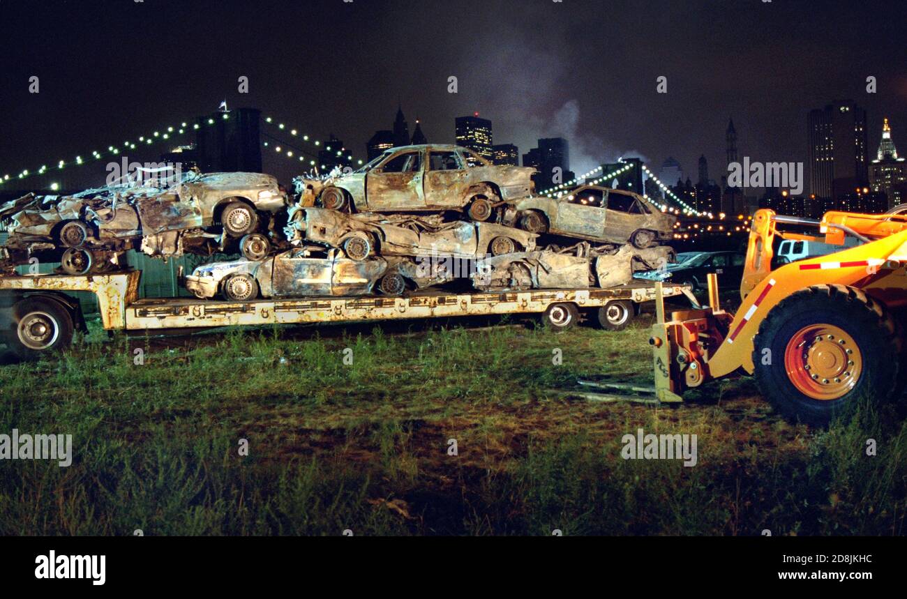 Les véhicules qui ont été écrasés à la suite de l'effondrement Du World Trade Center sont amenés à un temporaire Parking de stockage à Brooklyn sur un lit plat truc Banque D'Images