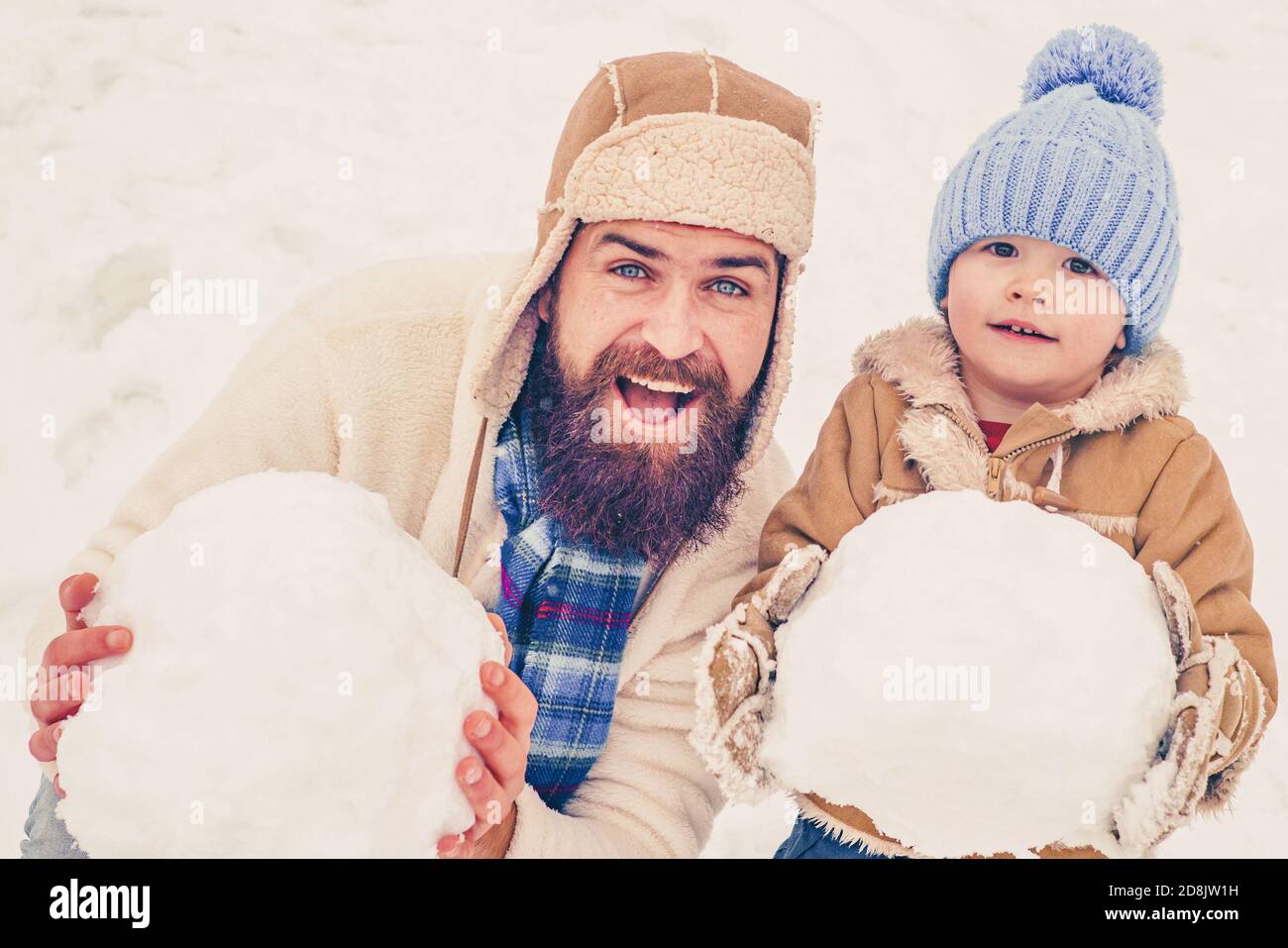 Papa et bébé fils jouant ensemble à l'extérieur. Père et fils d'hiver. Un  enfant heureux jouant avec un ballon de neige sur fond blanc d'hiver. Scène  d'hiver activée Photo Stock - Alamy