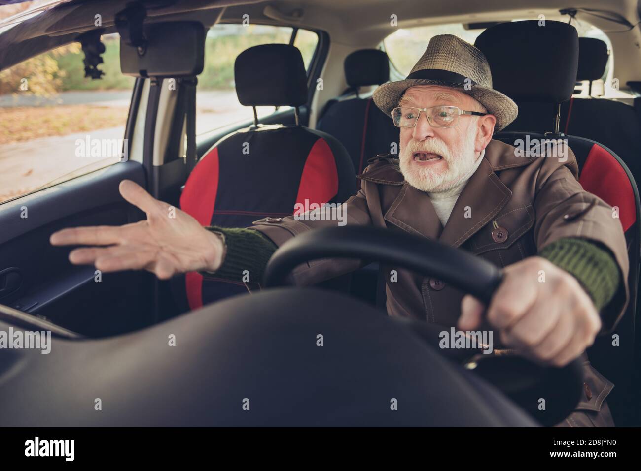 Portrait de son gentil expérimenté fou agacé furieux furieux furieux homme aux cheveux gris conduisant une voiture dans un embouteillage tenant le volant hurler Banque D'Images