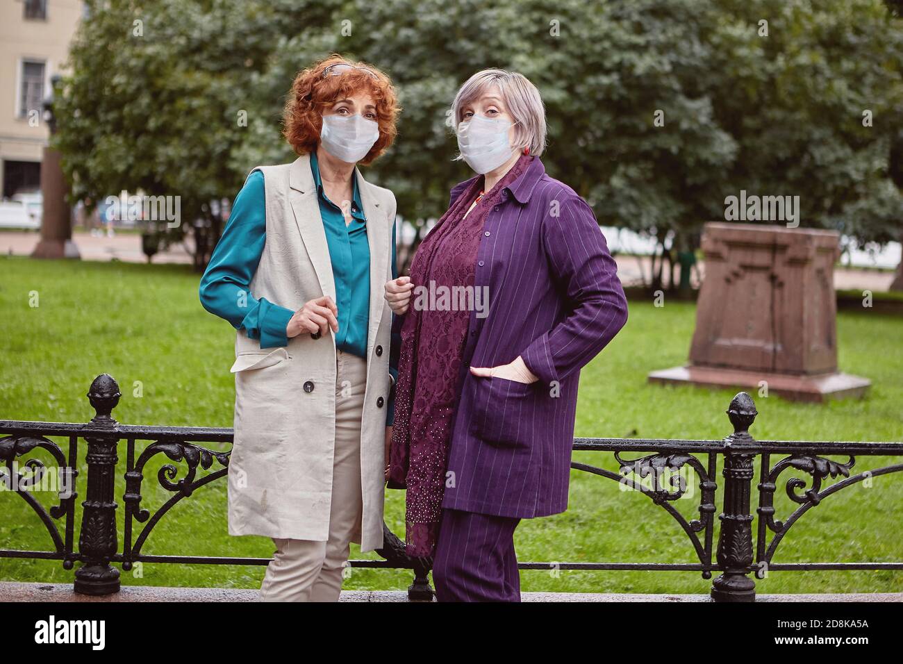 Les femmes matures attirantes dans les masques faciaux marche pendant la pandémie de Covid-19. Banque D'Images