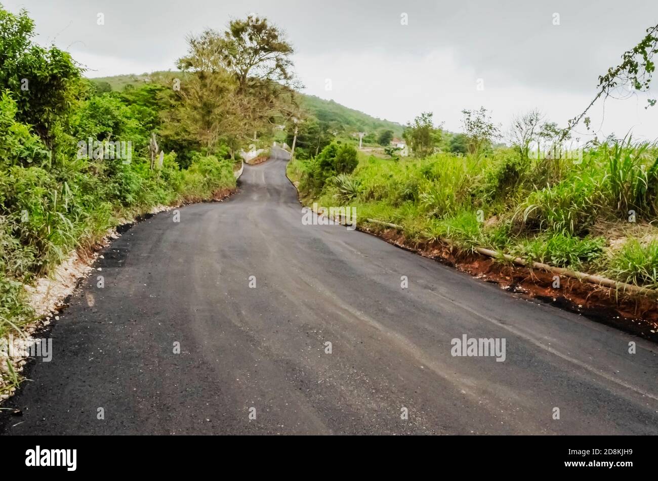 En regardant vers le bas une longue étendue de chemin légèrement sinueux vide de personnes qui a récemment resurfacé avec le béton d'asphalte. Banque D'Images