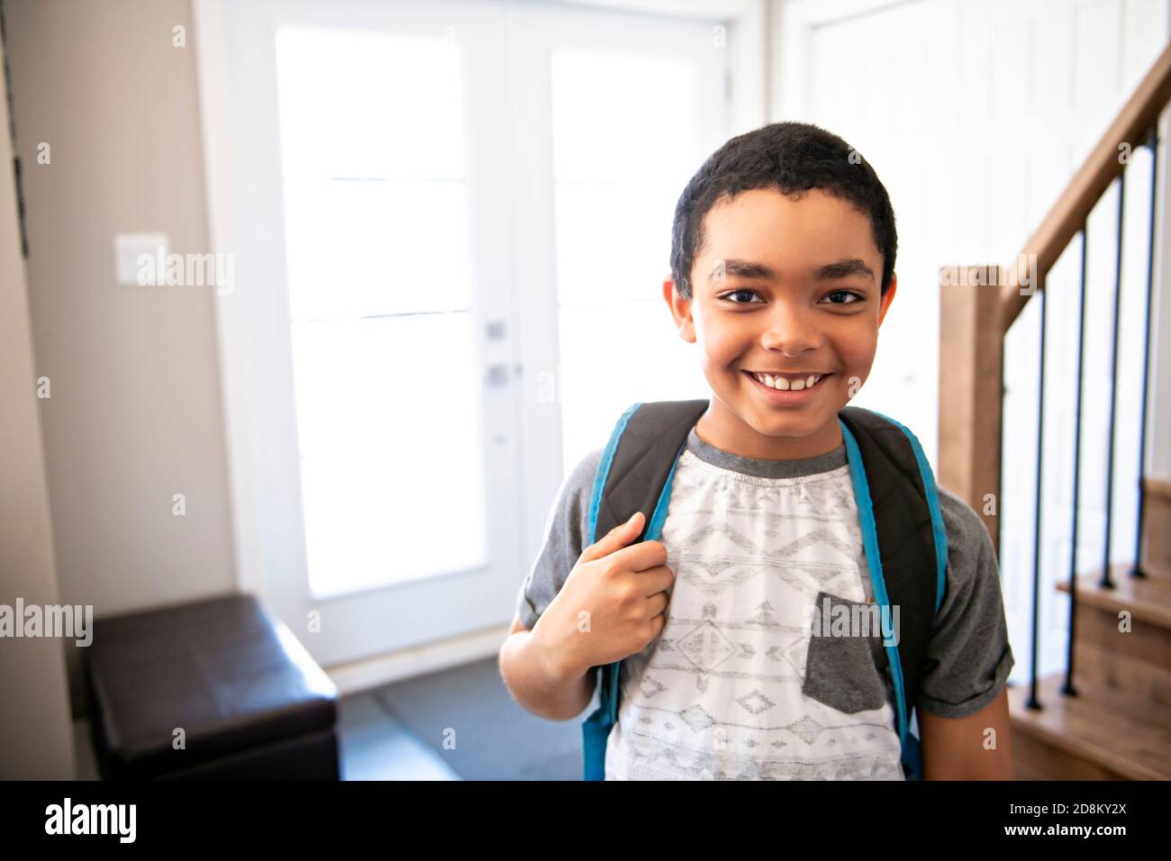 Un enfant qui rentre à la maison passe par la porte après école Banque D'Images