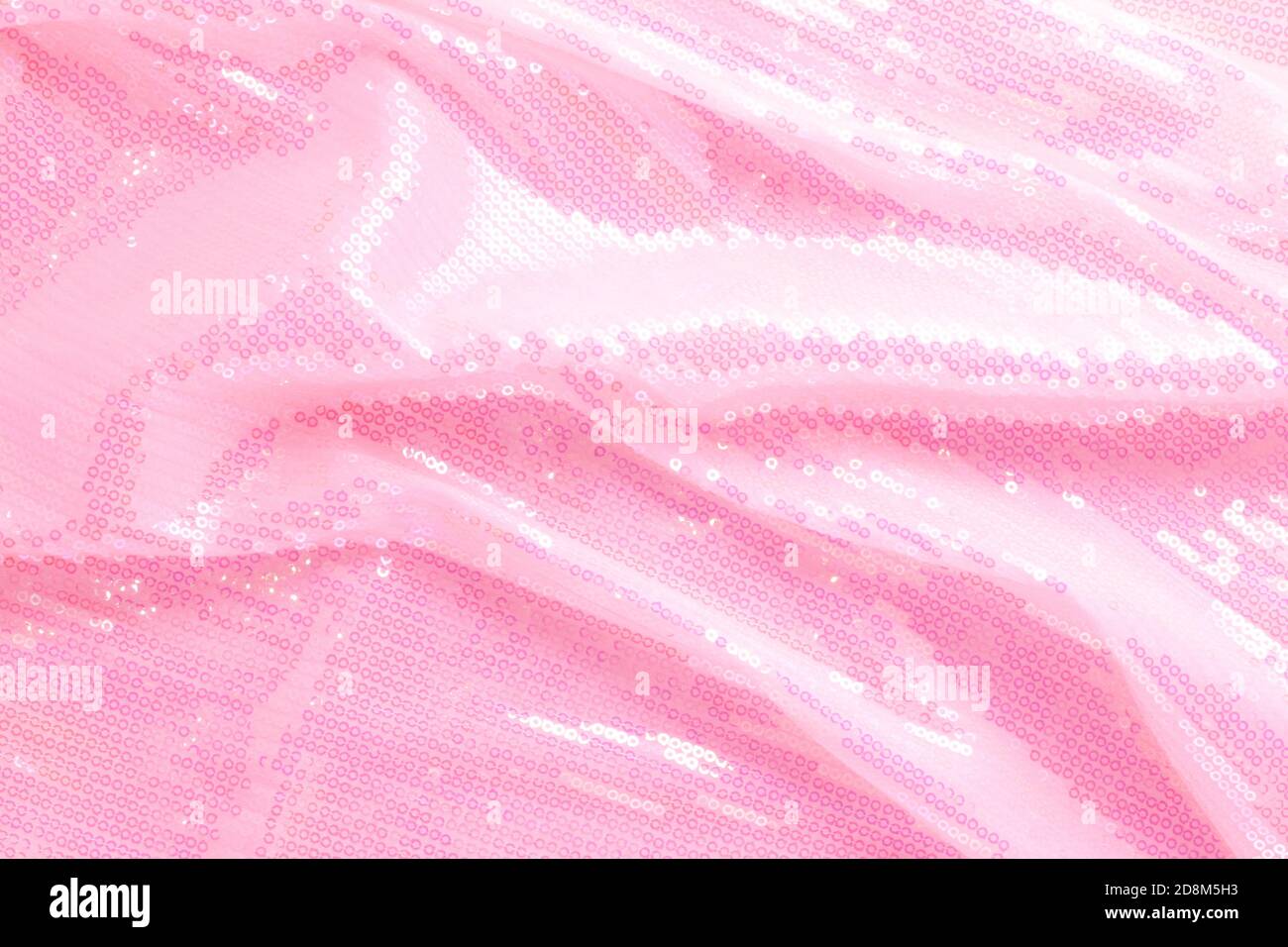 De grandes paillettes brillantes rose clair et brillantes remplissent entièrement l'espace d'arrière-plan. Banque D'Images