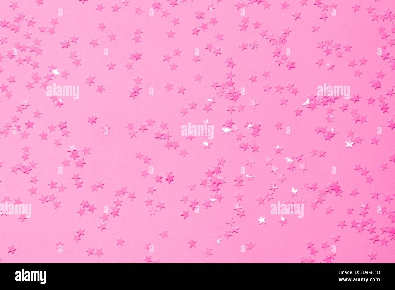 Paillettes roses sur fond rose avec confetti comme asterisks. Banque D'Images