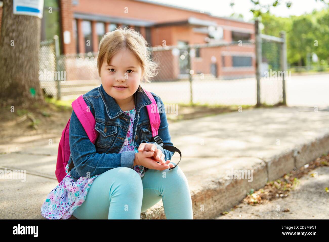 Un portrait de trisomie 21 enfant fille à l'extérieur sur un aire de jeux Banque D'Images