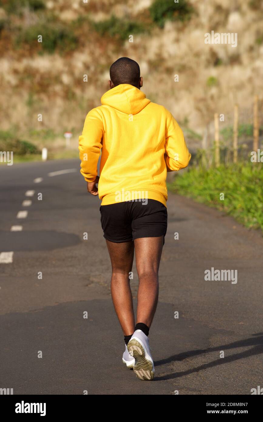 Portrait complet de l'arrière de l'homme sportif afro-américain course dans la rue Banque D'Images