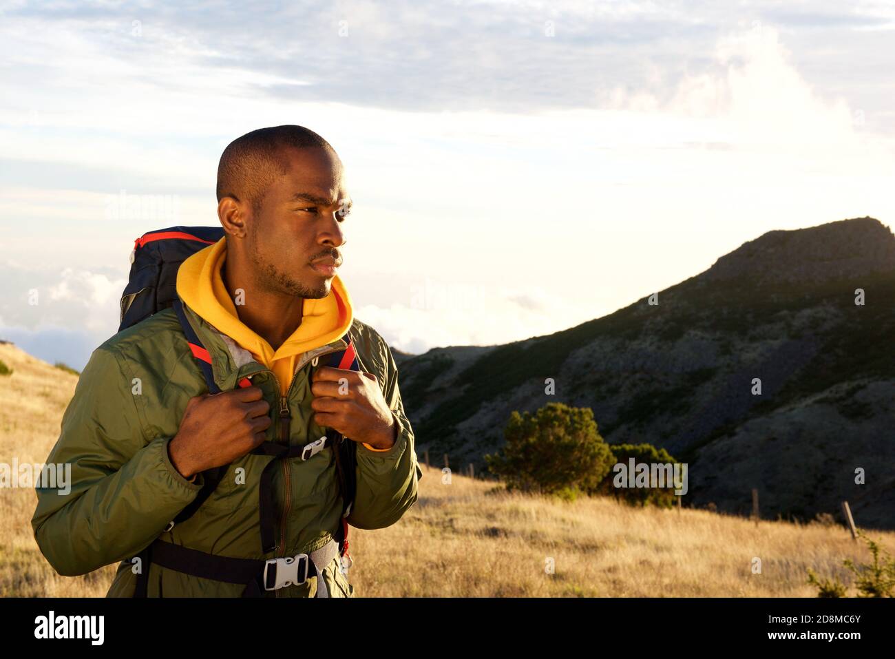 Portrait latéral de l'homme afro-américain en randonnée dans les montagnes avec sac à dos Banque D'Images