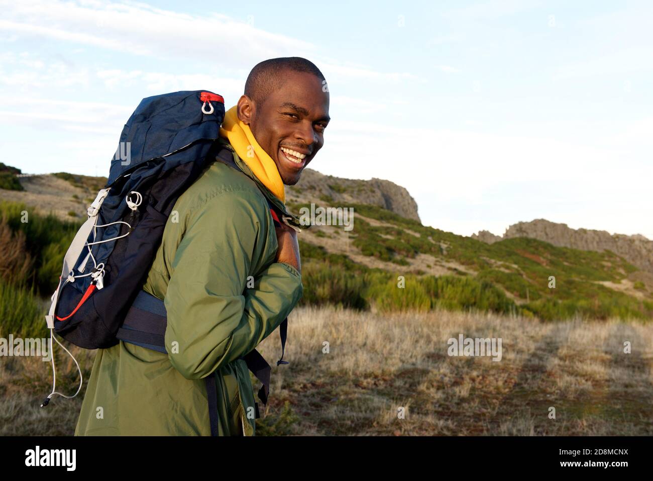 Portrait latéral d'un homme afro-américain heureux en randonnée avec sac à dos dans les montagnes Banque D'Images
