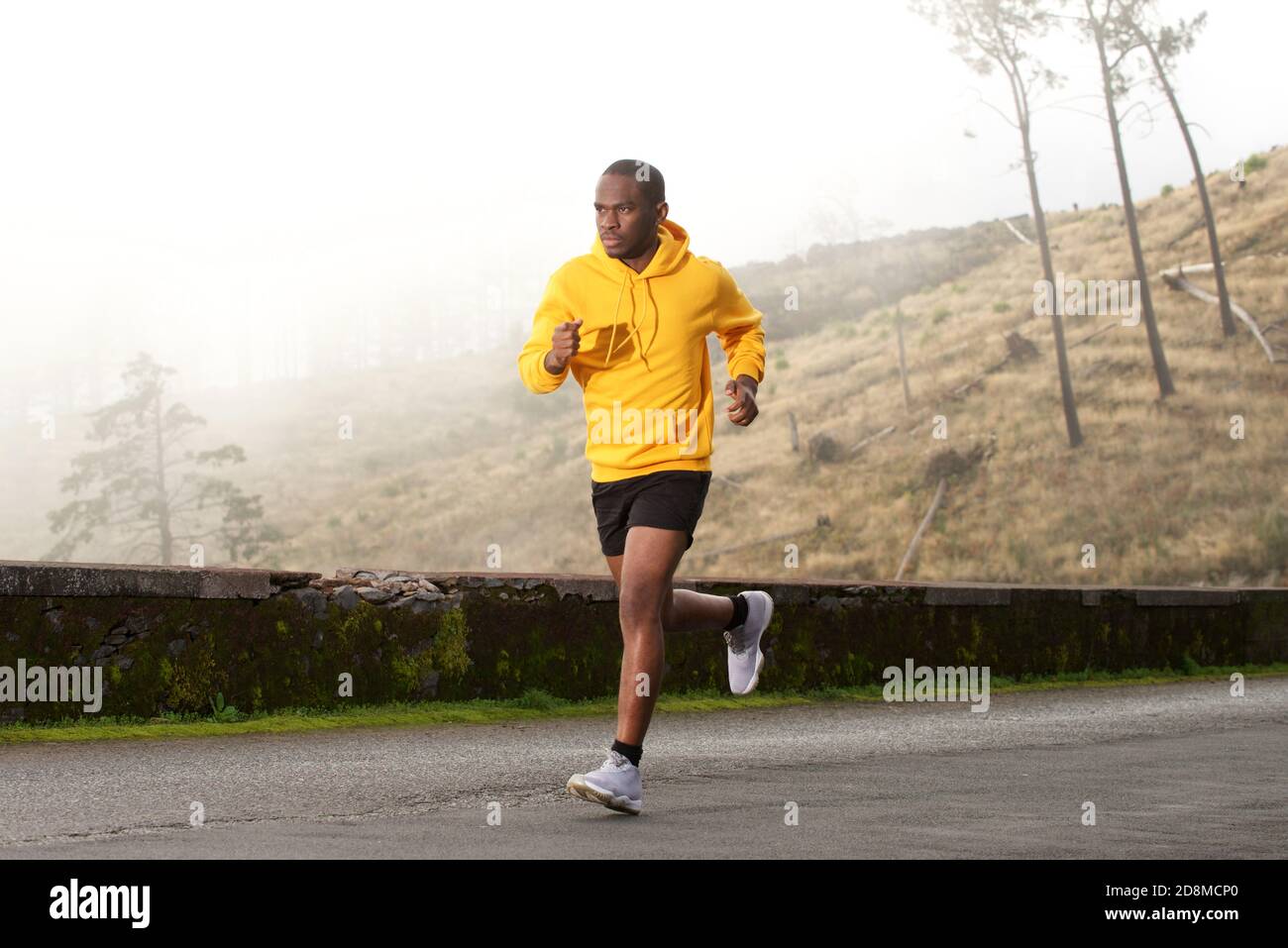 Portrait latéral complet d'un jeune homme afro-américain en bonne santé course dans la rue Banque D'Images