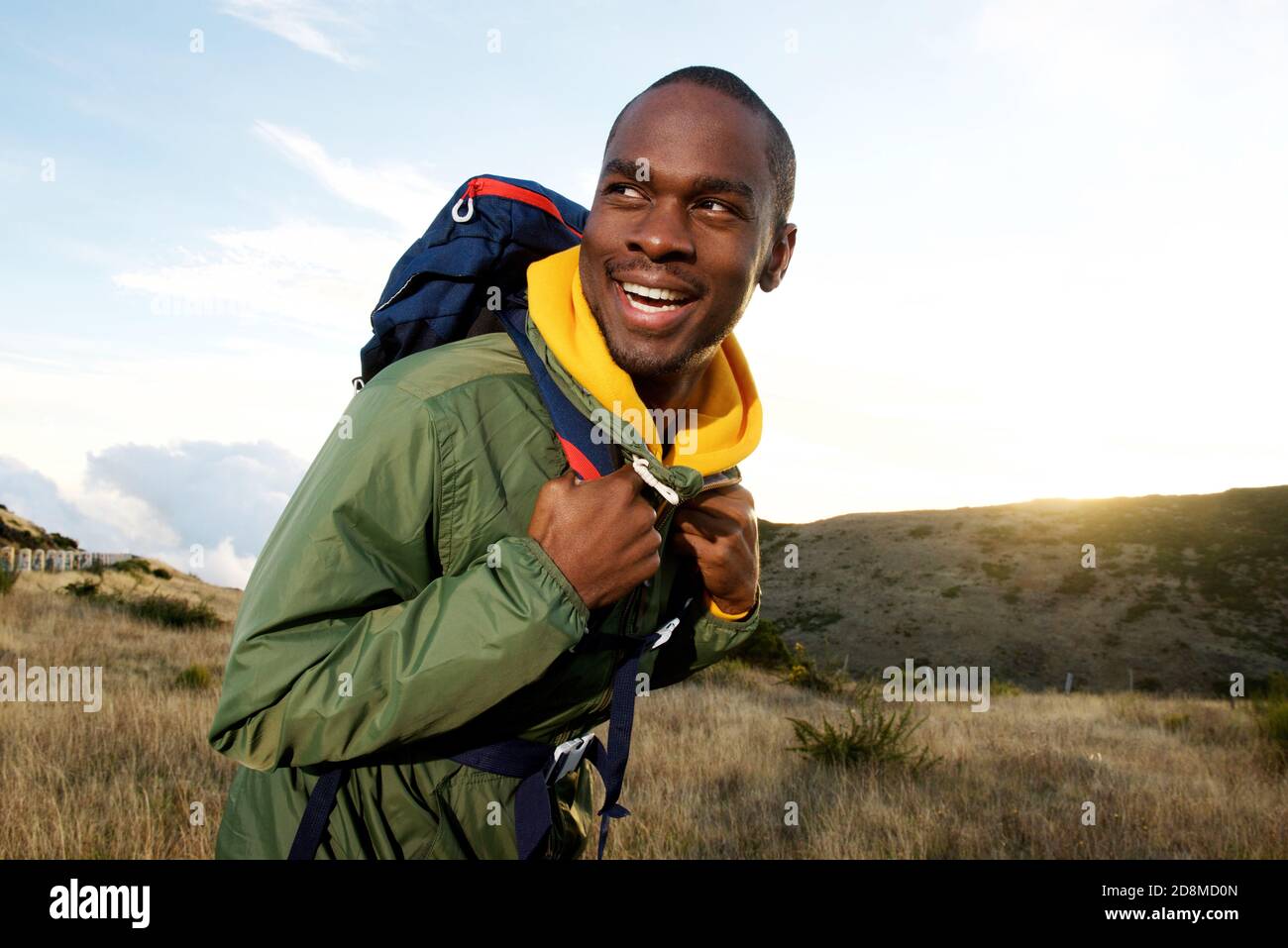 Portrait latéral d'un homme afro-américain souriant avec randonnée à dos en montagne Banque D'Images