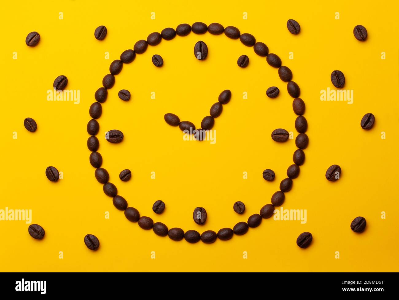 Composition créative de grains de café sous forme de cadran sur fond de papier jaune. Banque D'Images