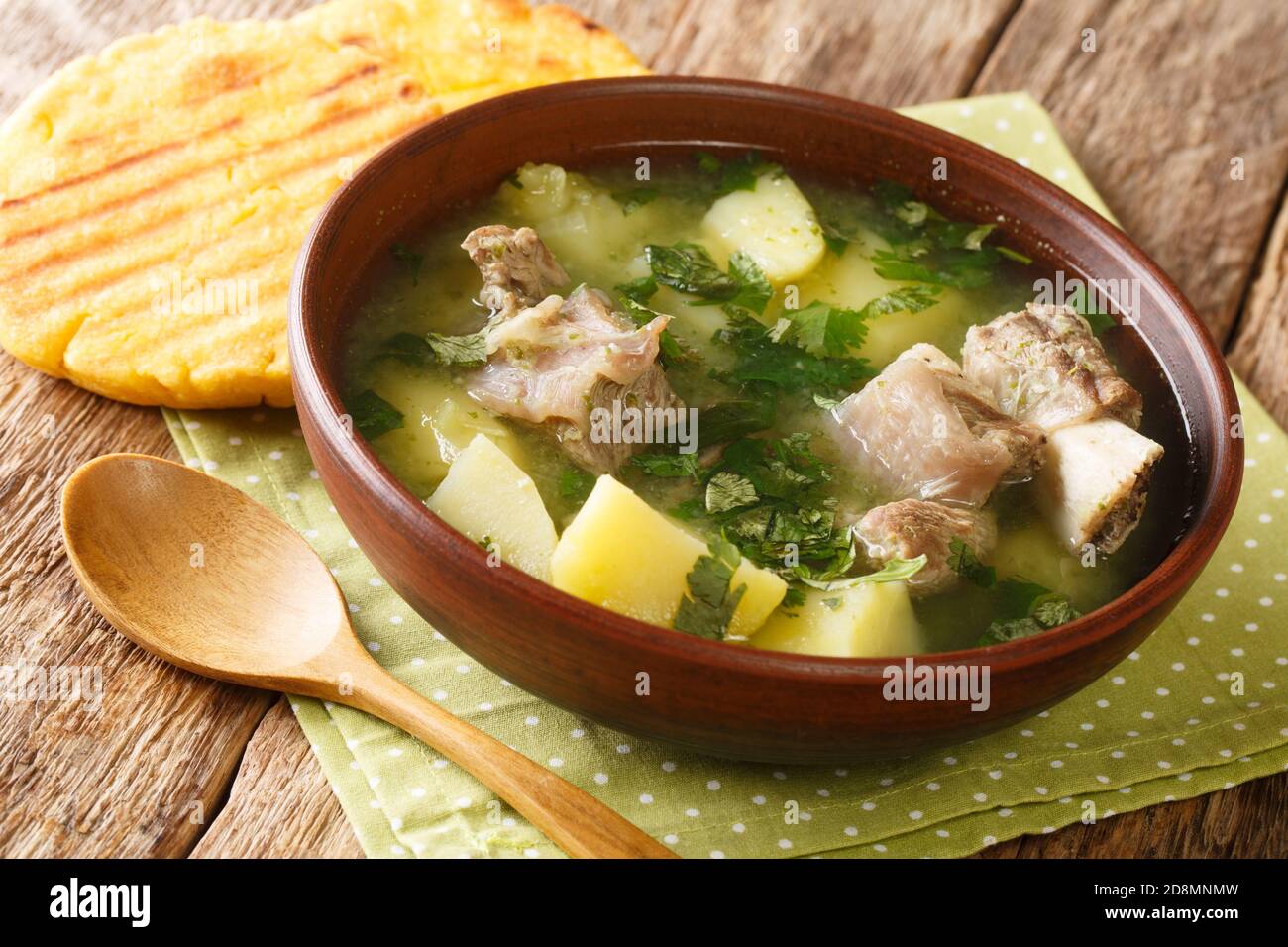 Délicieuse soupe traditionnelle de côtes de bœuf avec pommes de terre et herbes Caldo de costilla dans un bol sur la table. Horizontale Banque D'Images