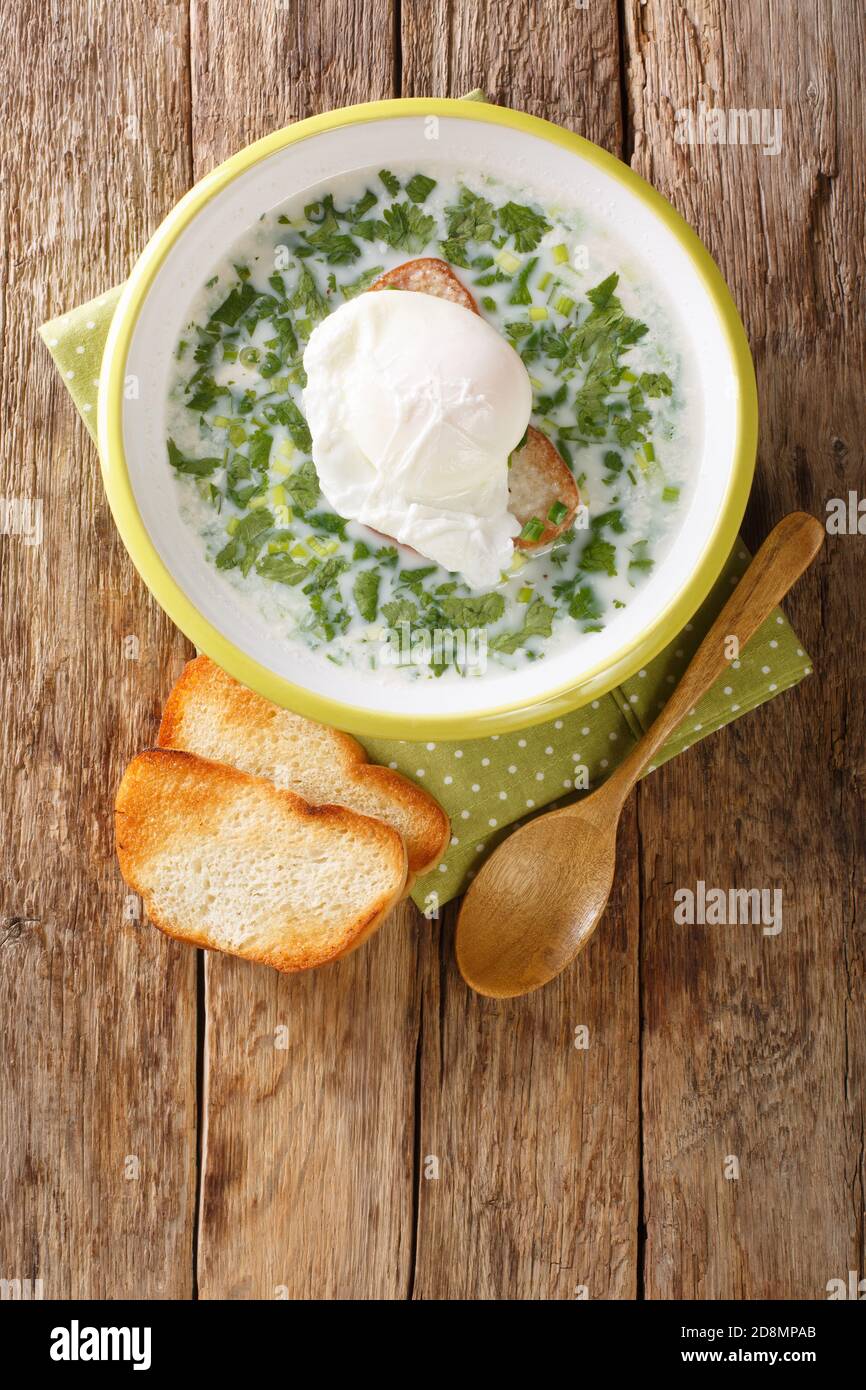 Changua est une soupe colombienne de petit-déjeuner qui est à la fois délicieux et réconfortant gros plan dans l'assiette sur la table. Vue verticale du dessus Banque D'Images