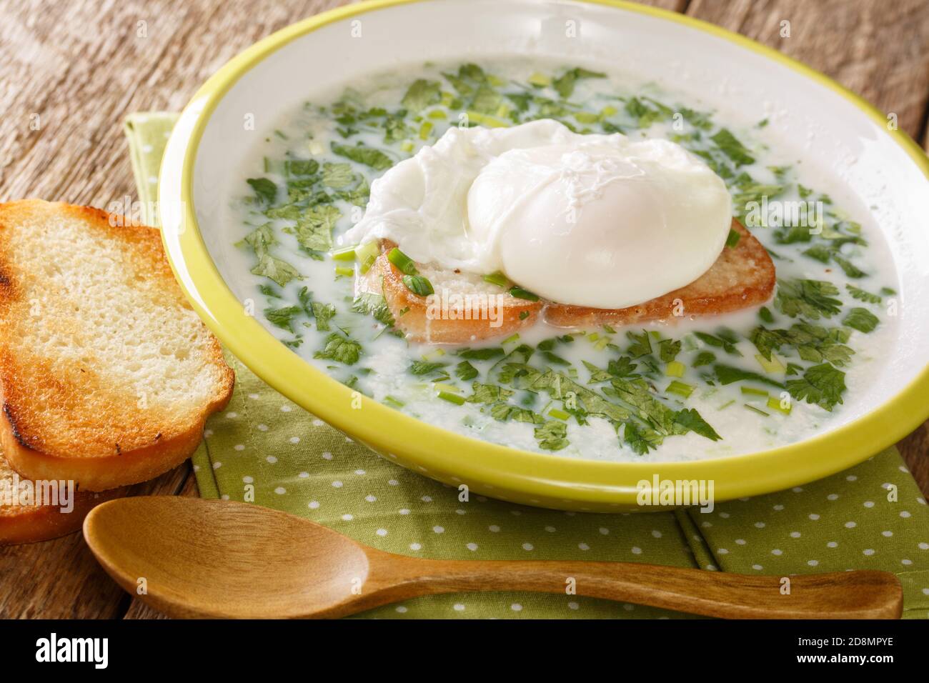 Soupe de lait de petit déjeuner colombien Changua dans la plaque sur la table. Horizontale Banque D'Images