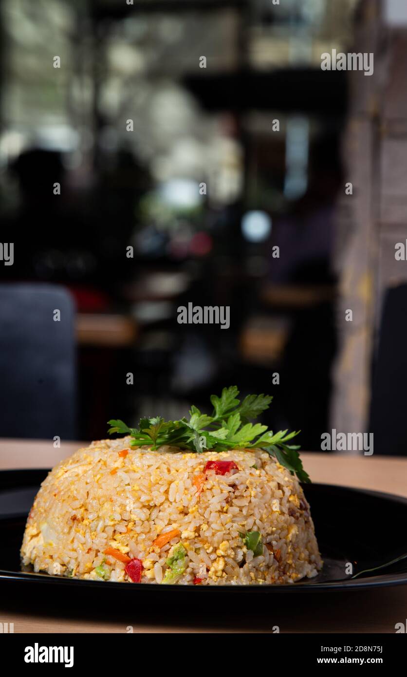 Dose verticale de délicieux riz sauté avec poulet et légumes sur une plaque sur la table Banque D'Images