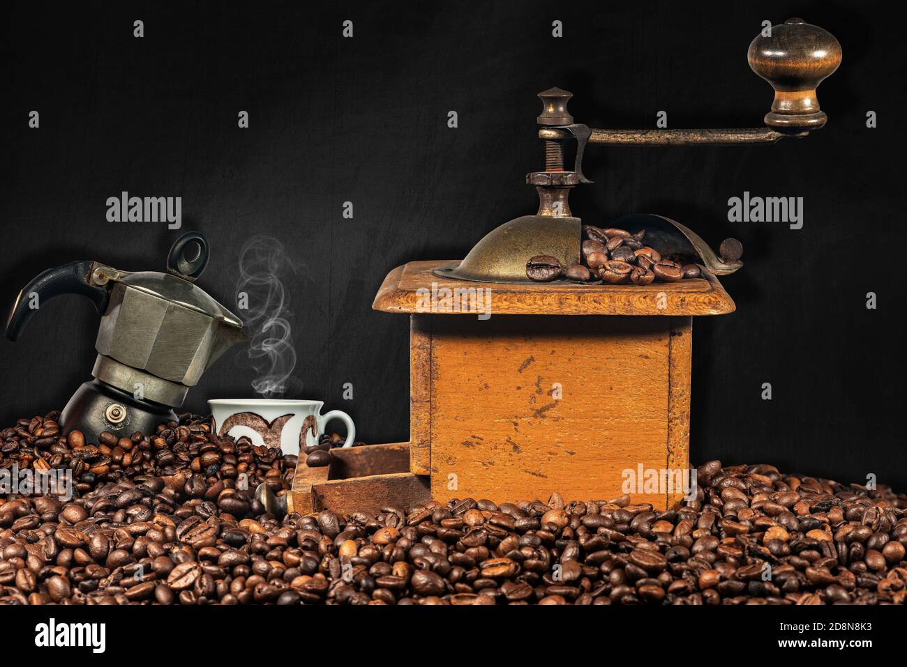 Ancien moulin à café manuel, cafetière italienne et une tasse sur une pile  de grains de café torréfiés avec un tableau noir vide en arrière-plan Photo  Stock - Alamy