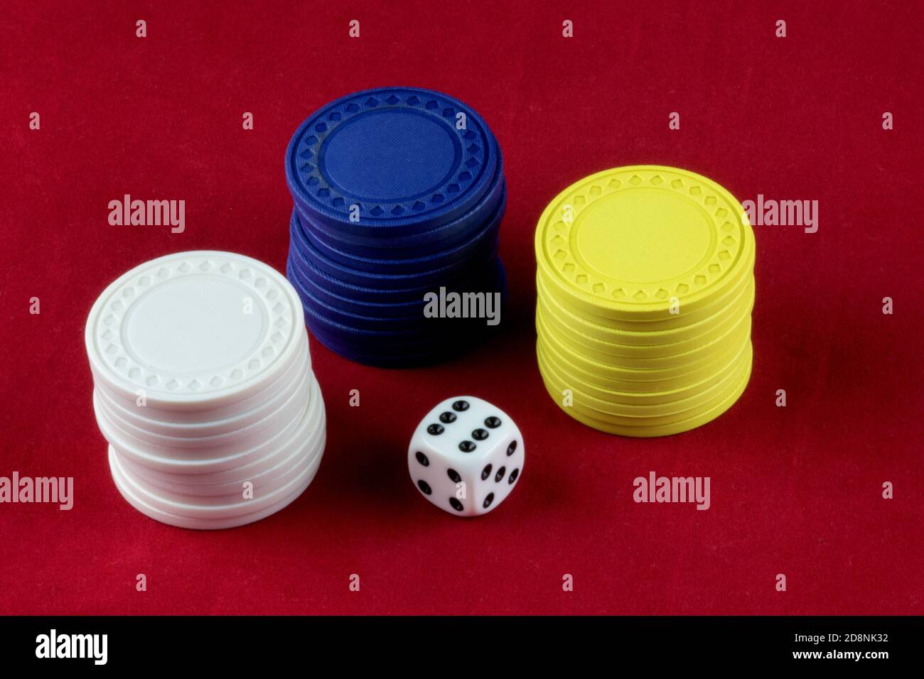 Jetons de jeu colorés et matrice blanche sur fond rouge Banque D'Images