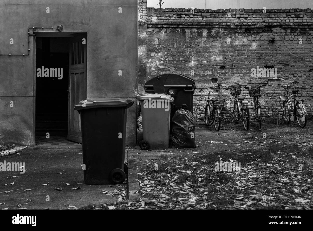 Poubelle dans une cour arrière, poubelles dans une cour arrière de Berlin, photo en noir et blanc Banque D'Images