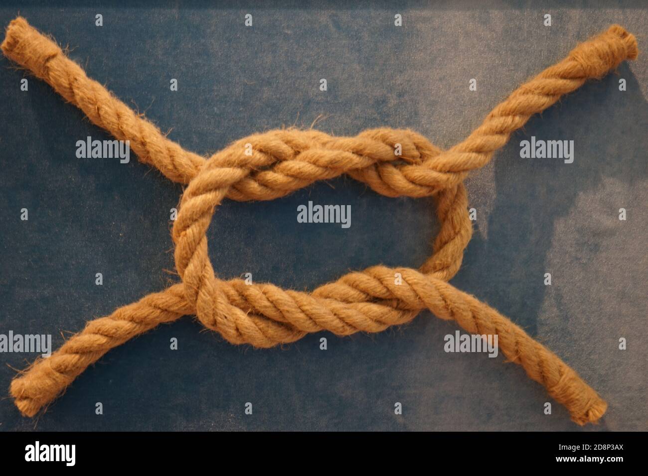 symbole d'un nœud de mer fait de corde sur un arrière-plan bleu Banque D'Images