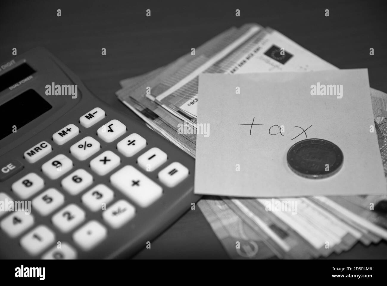 Impôt sur le revenu inscrit sur un billet post-it avec des billets de banque, une pièce de monnaie et une calculatrice. Concept: Paiement d'impôt sur le revenu. Banque D'Images