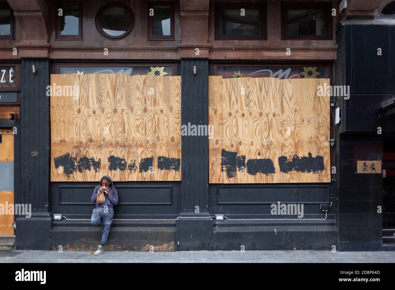 Un travailleur manuel, masculin, se tient à l'extérieur d'un restaurant à bord en train de manger son déjeuner pendant la pandémie de COVID de 2020. Leicester Square, Londres, Angleterre, Royaume-Uni Banque D'Images