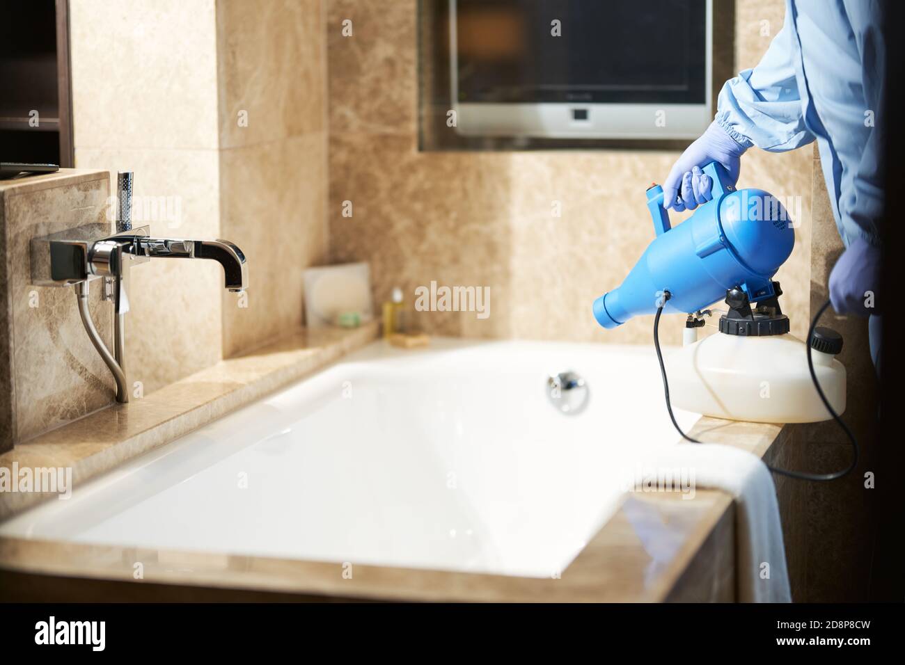 Photo de l'homme en culture utilisant un désinfectant pour prévenir le risque d'apparition de coronavirus dans la salle de bains. Coronavirus et concept de quarantaine Banque D'Images