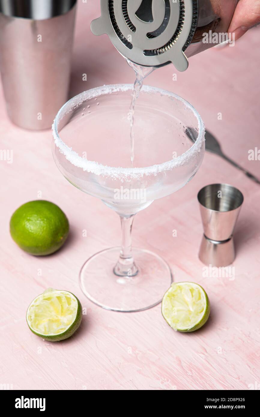 La main de l'homme verse la boisson dans un verre à cocktail. Préparation de Margarita Banque D'Images