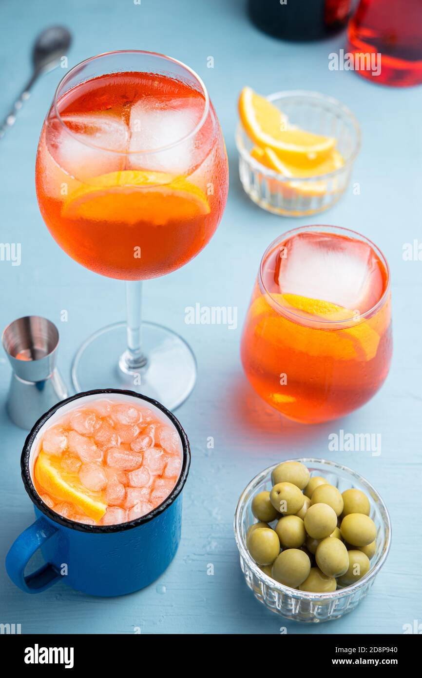 Différents verres de cocktail italien classique Spritz avec olives une table bleue Banque D'Images