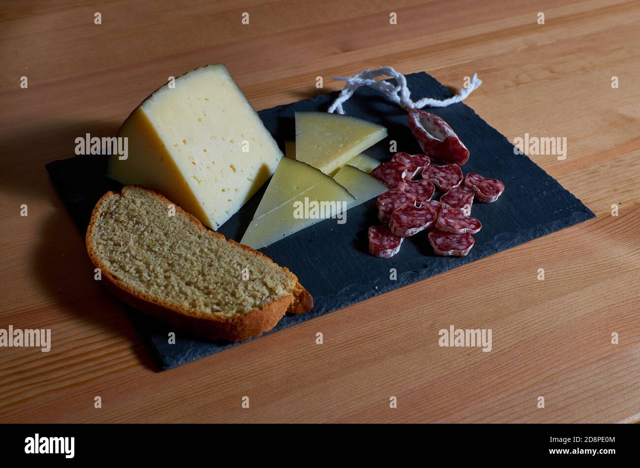 Gros plan de vieux fromage de brebis et fuet sur ardoise plaque Banque D'Images