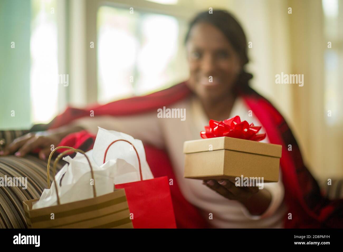 Femme d'âge mûr assise sur son canapé à la maison. Banque D'Images