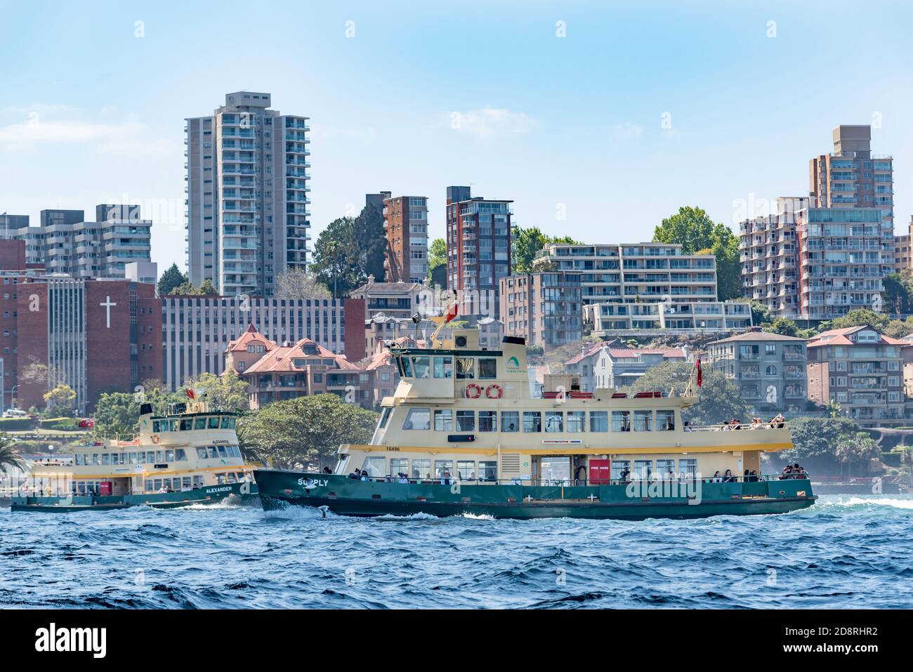 Deux traversiers de première classe de la flotte de Sydney traversent des sentiers près du Sydney Harbour Bridge à Sydney, en Australie, au cours d'un après-midi printanier ensoleillé Banque D'Images