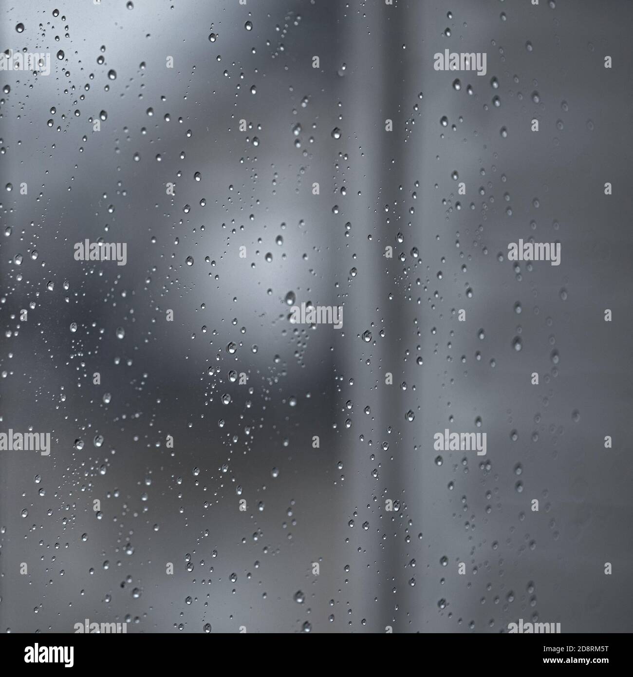 L'eau de pluie tombe sur une vitre noire spectaculaire. Arrière-plan de dépression de bokeh d'automne. Motif pluie Banque D'Images