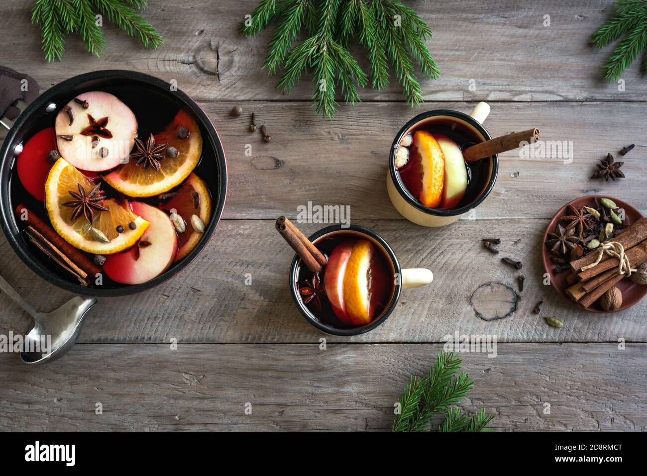 Vin rouge de Noël chaud aux épices et aux oranges sur une table rustique en bois. Boisson chaude traditionnelle pour les vacances de Noël et d'hiver, vue du dessus. Banque D'Images