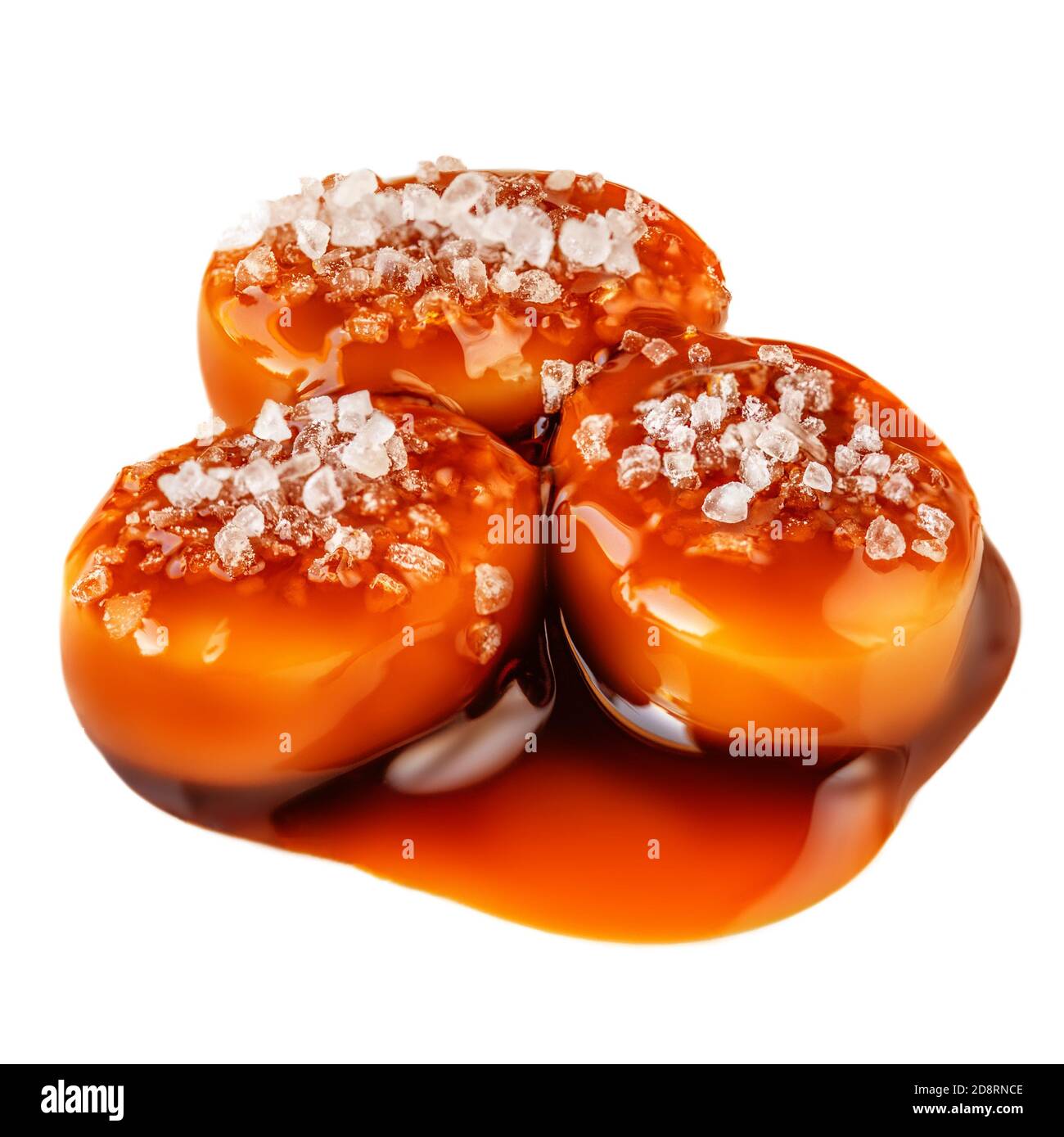 Sucreries sucrées avec garniture au caramel salé isolées sur fond blanc. Toffee avec sauce caramel gros plan. Banque D'Images