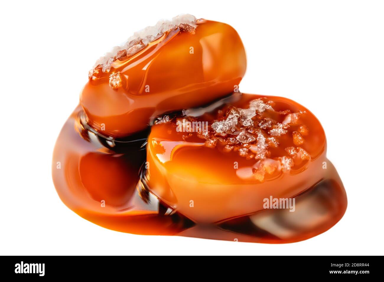 Bonbons salés au caramel avec sauce au caramel isolés sur fond blanc de près. Banque D'Images