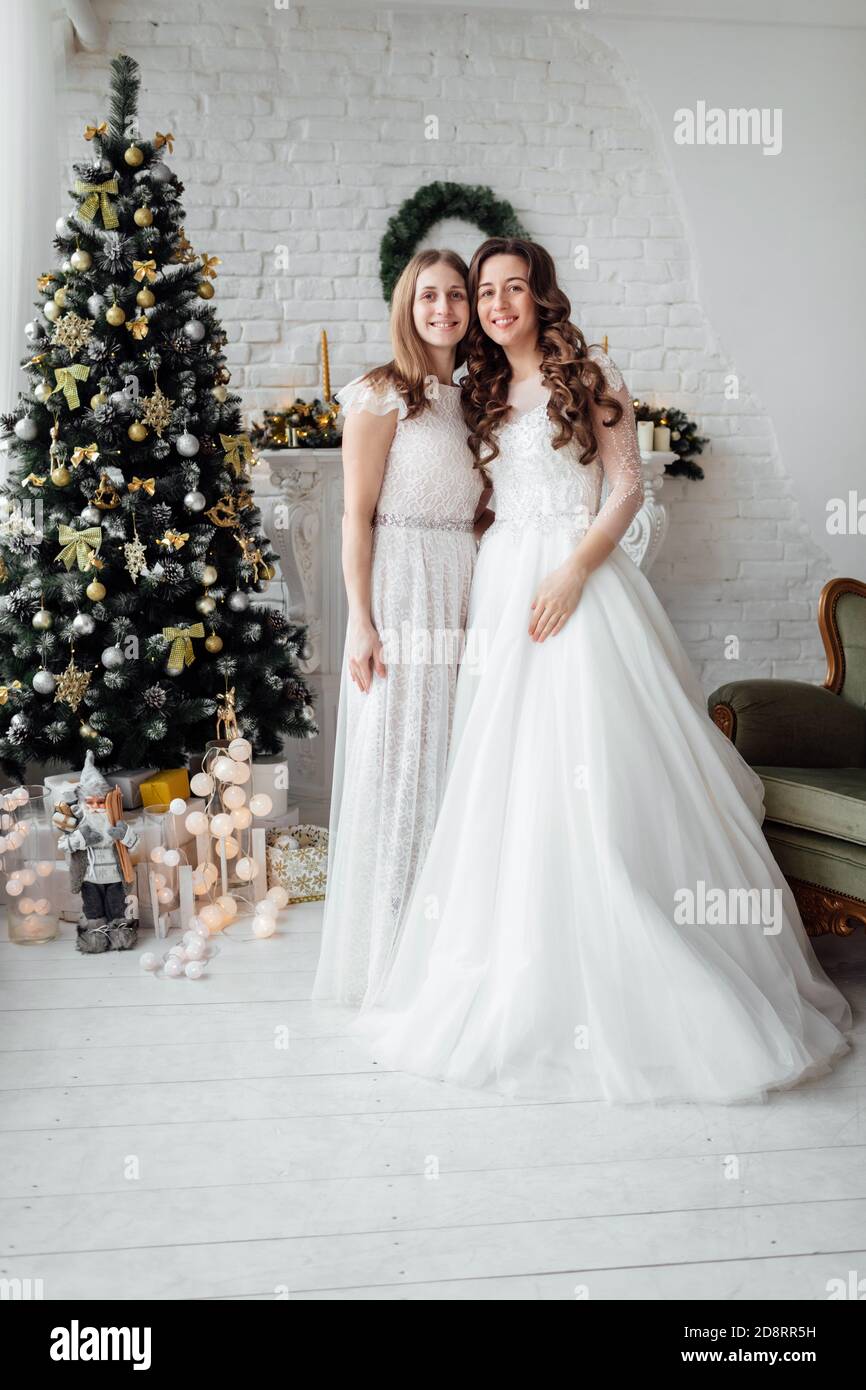 Belle mariée de luxe robe de mariage et jolie demoiselle d'honneur dans le  studio de noël décoré. Mariage à Noël Photo Stock - Alamy