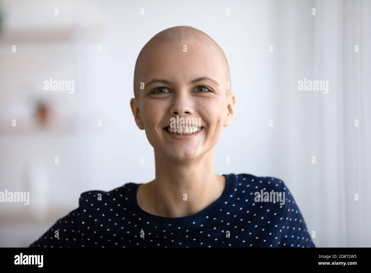 Tête prise de vue portrait sourire femme sans cheveux regardant l'appareil photo Banque D'Images