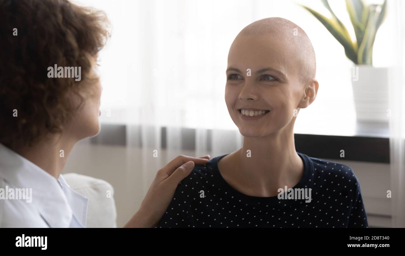 Gros plan médecin traitant touchant sourire femme sans cheveux épaule Banque D'Images