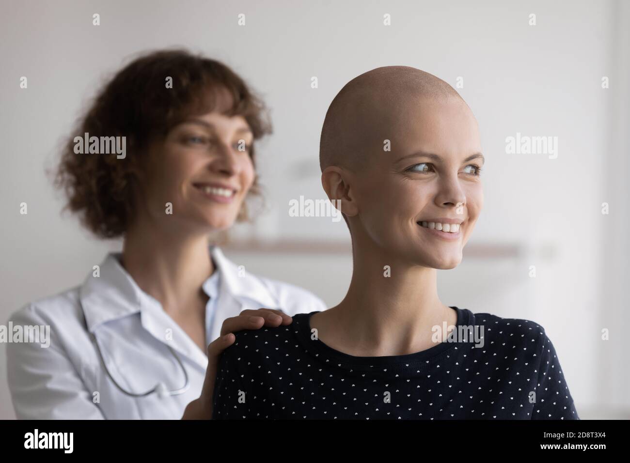 Gros plan sourire femme sans cheveux avec le médecin regardant de côté Banque D'Images