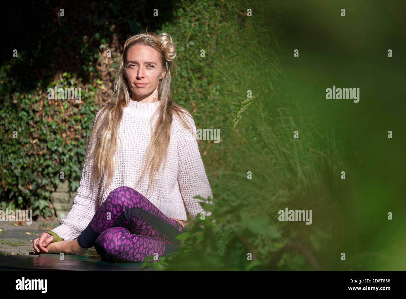 Femme blonde, quarante ans pratiquant le yoga pose dans un environnement extérieur, Londres, Angleterre Banque D'Images