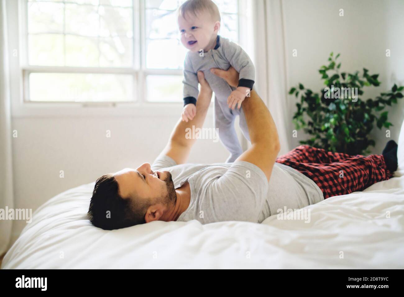 Un père avec un bébé mignon sur le lit à la maison Banque D'Images